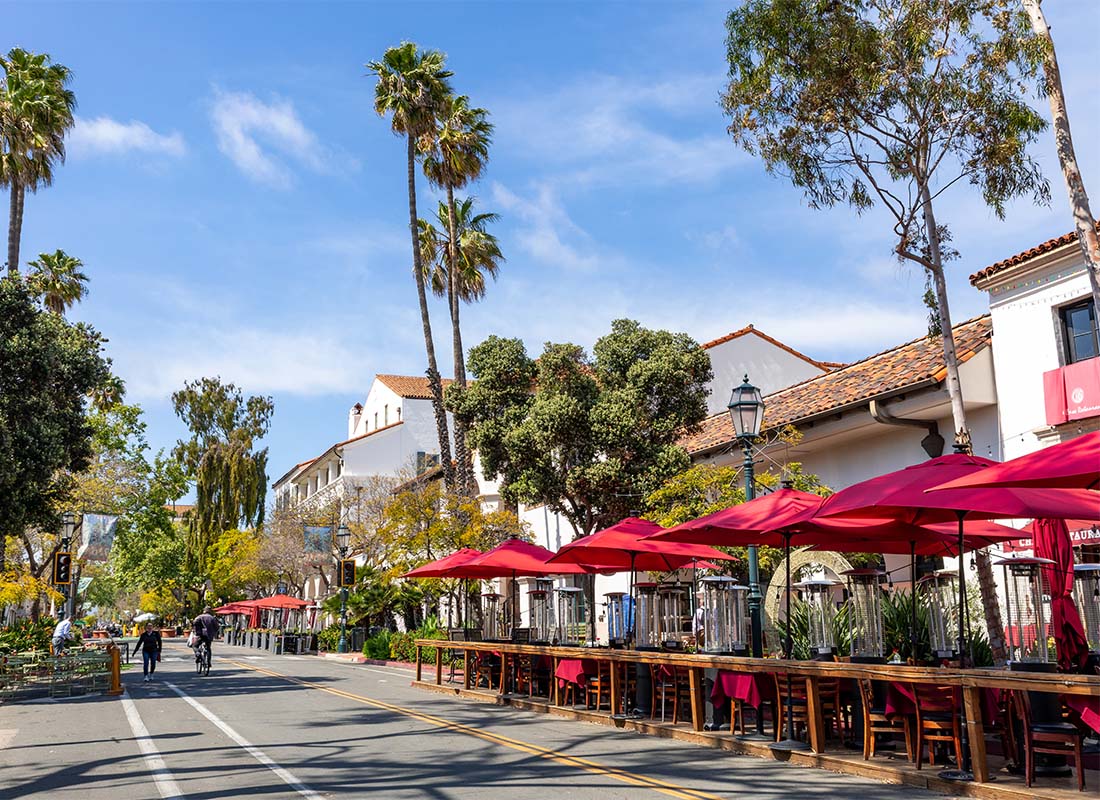 Insurance Solutions - View of a Shopping and Restaurant Area in Santa Barbara with Outdoor Seating with Red Umbrellas on a Sunny Day